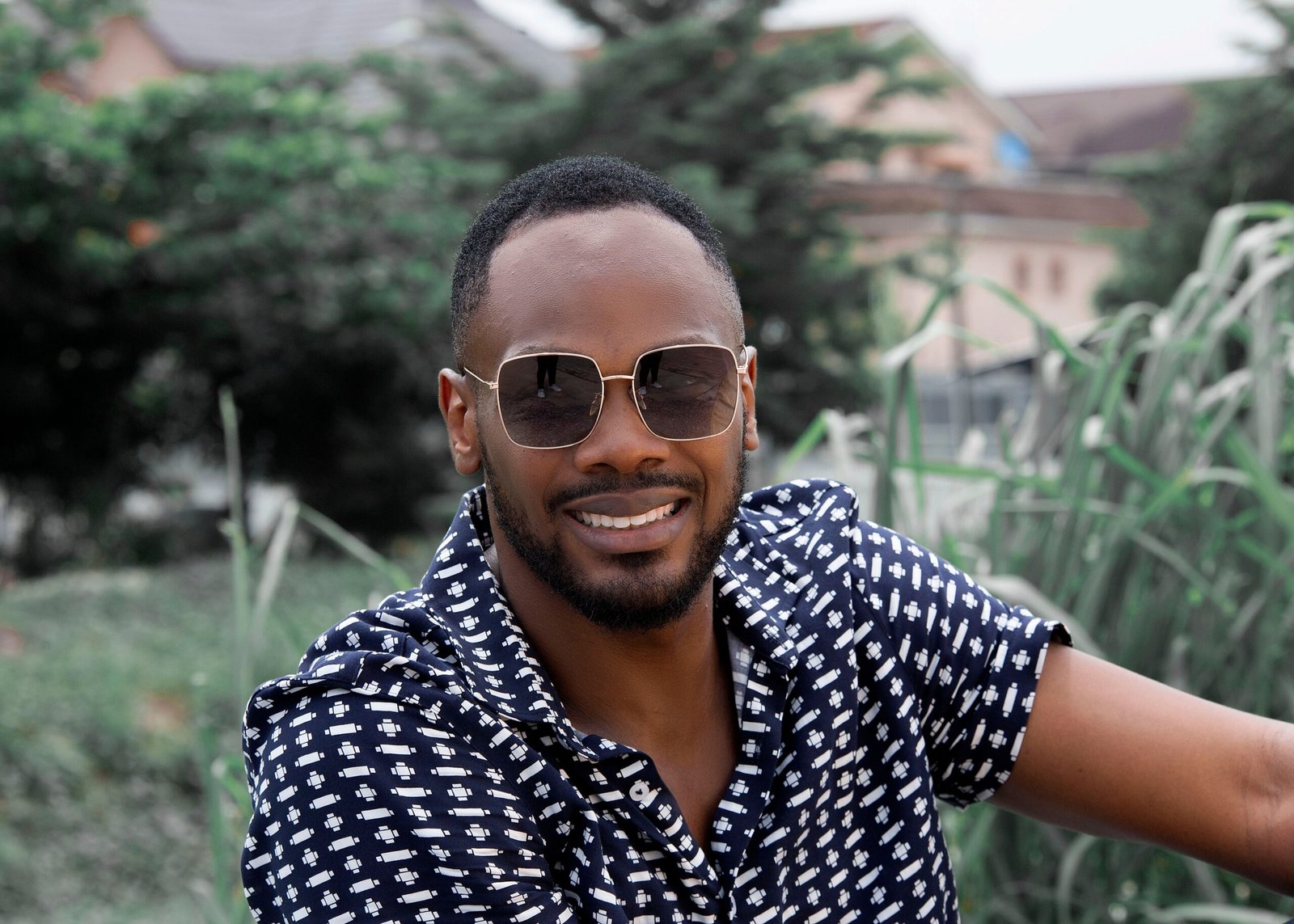 Portrait of a stylish black man with sunglasses smiling outdoors in Lagos, Nigeria.